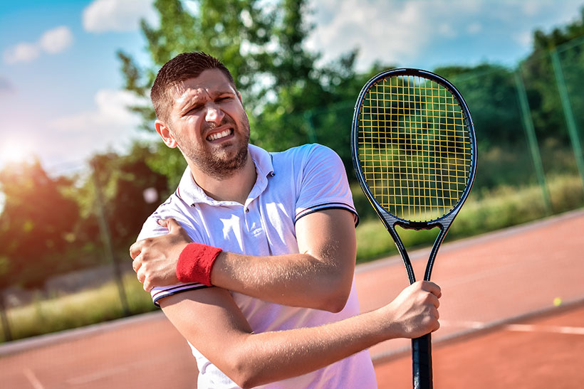 Tennisspieler hält sich während des Spiels die rechte Schulter vor Schmerzen